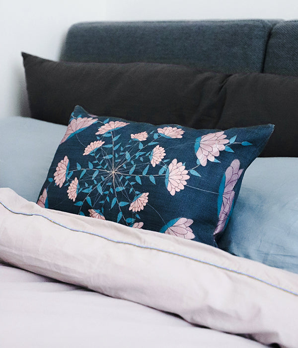14" x 20" 100% cotton dark grey pillow cover with an illustration of several pink flowers spiralling out from the middle