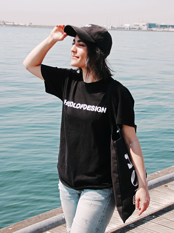 girl in school of design black cotton t shirt and black tote