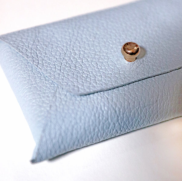 blue, rectangular leather card holder, closed. Close up.