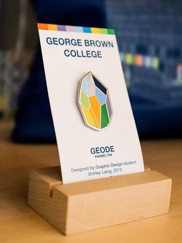 geode enamel pin backed on white GBC card, displayed on wooden block