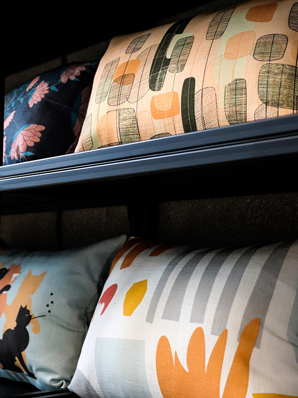 pillows displayed on shelves; Abstract Flower Pillow Cover on top shelf, abstract Pillow Cover on bottom shelf
