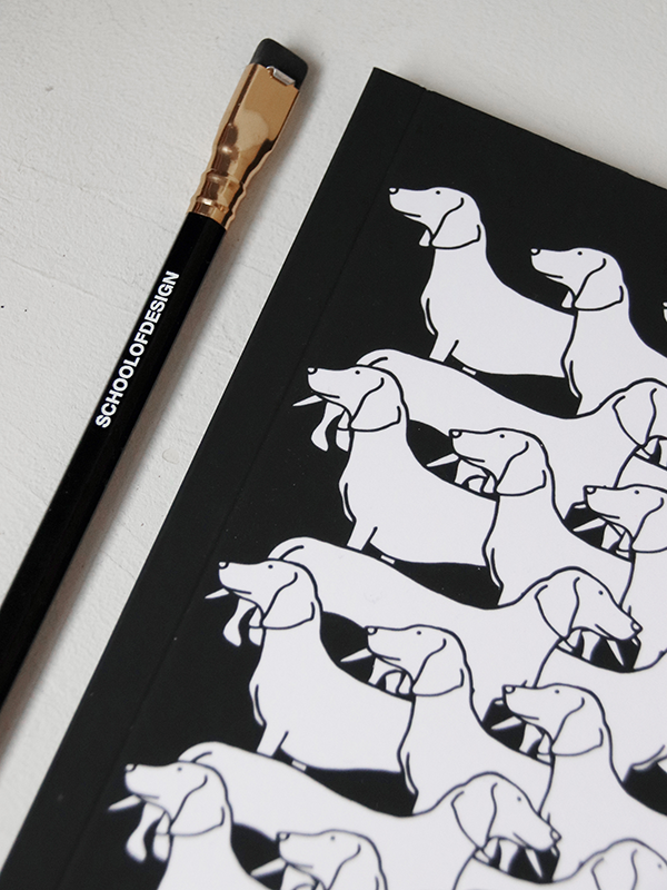 close up of black notebook with horizontal dog illustration pattern in white and school of design black pencil