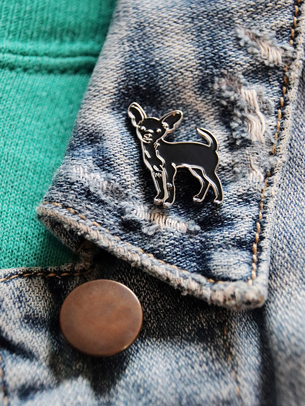 black chihuahua enamel pin featured on a denim jacket