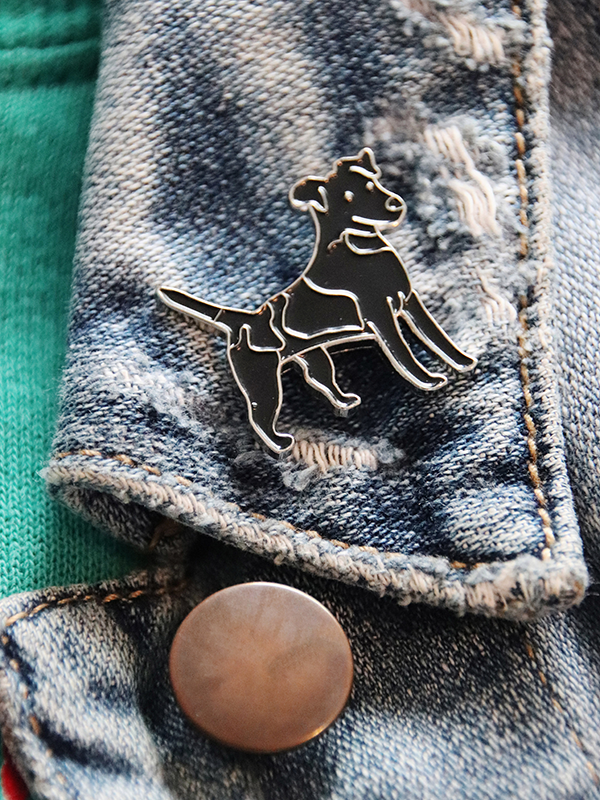 black dog enamel pin featured on a denim jacket